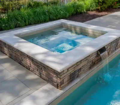 Therma Spa — square fiberglass spa installed with stone coping